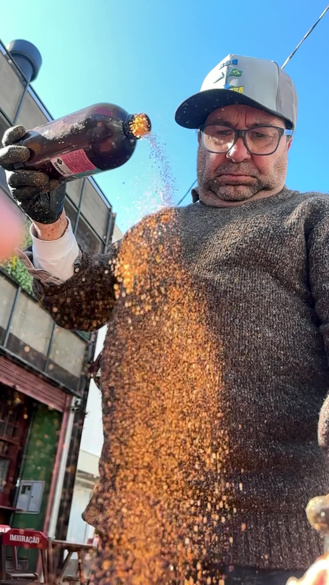 O Dani jogando o tempero do alto sobre a carne